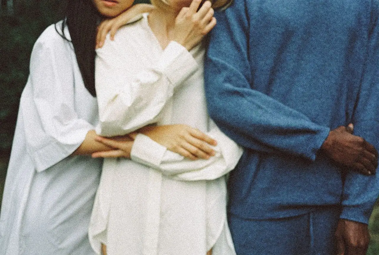 Three people standing close together